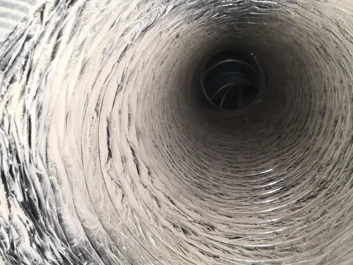 Air duct interior before cleaning — heavy dust and debris buildup (Raleigh-area job by The Air Ducters)